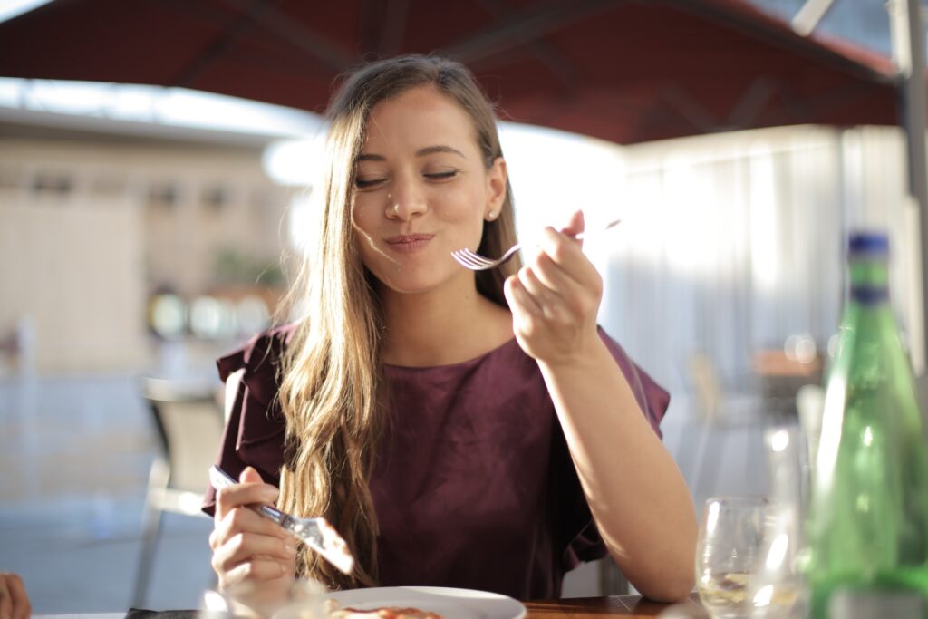 A girl having her meal with fork and knife