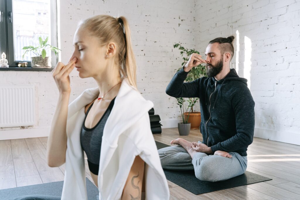 A woman and a man doing breathing exercise as one of self-esteem building activities