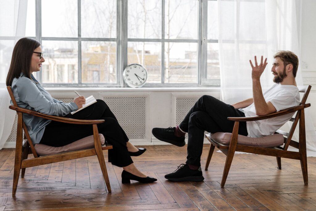 Two people discussing sitting on wooden chair