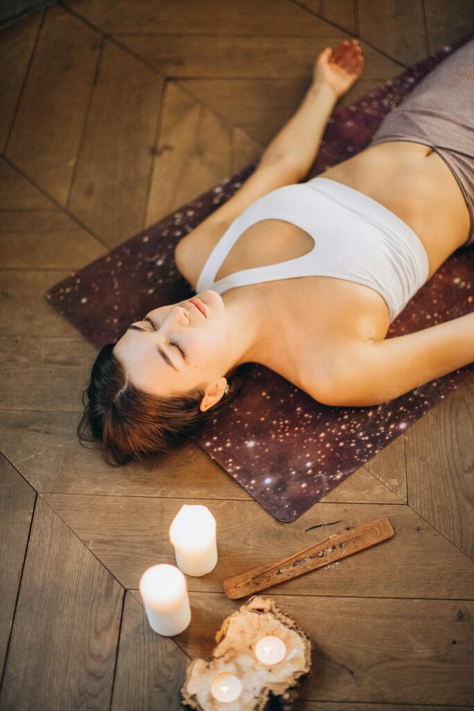 A lady laying on the yoga mat and practicing meditation
