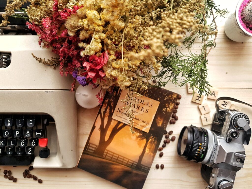 A flower bouquet, a camera and a book on the table