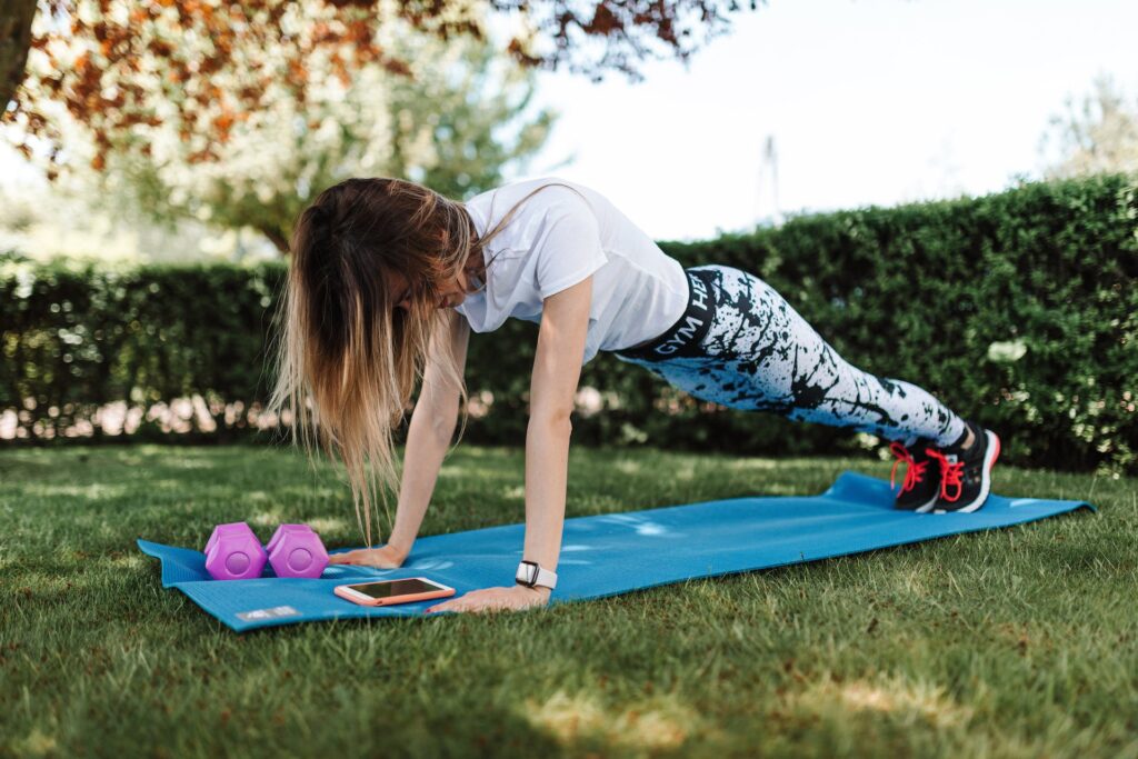 A girl doing workouts on a blue yoga mat