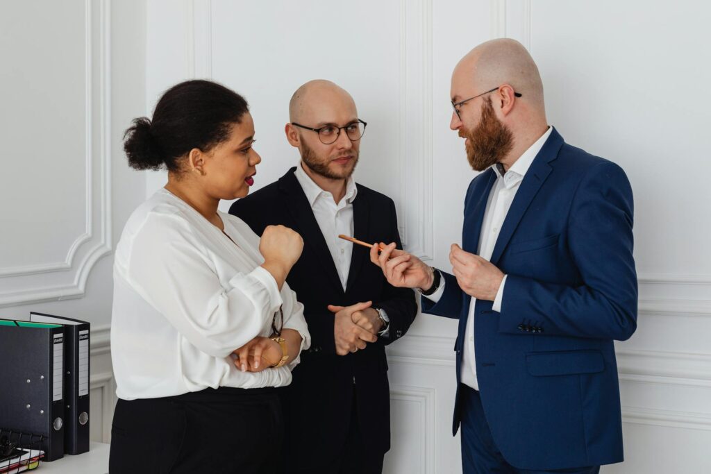 A woman and two men discussing in the office