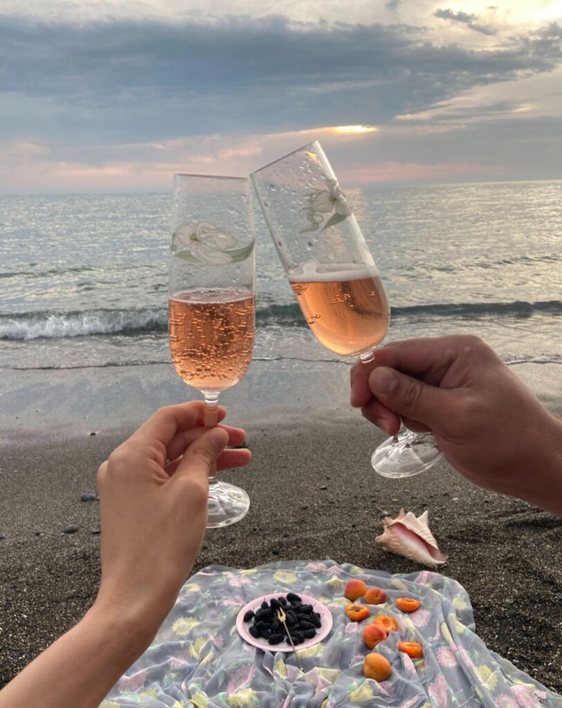 A couple with two wine glasses on the beach