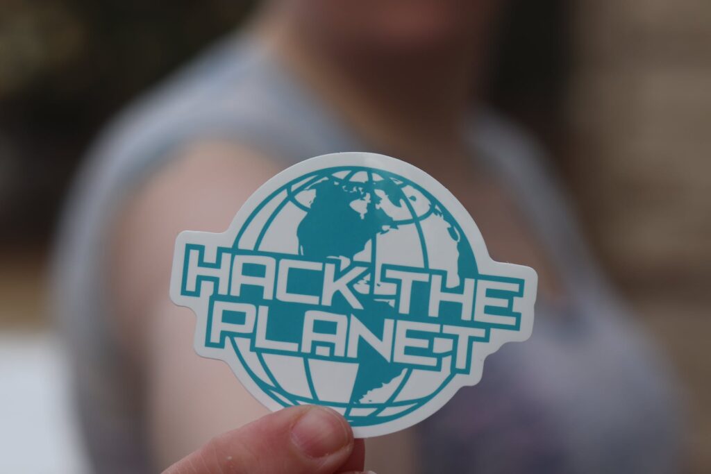 A person hold "Hack the planet" logo sticker 