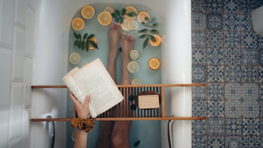 Relaxing in a bathtub while reading a book is one of the best self-care activities at home