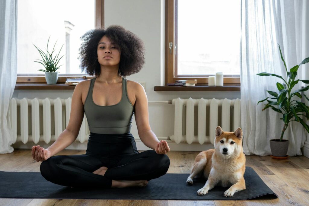 A woman doing meditation beside a dog