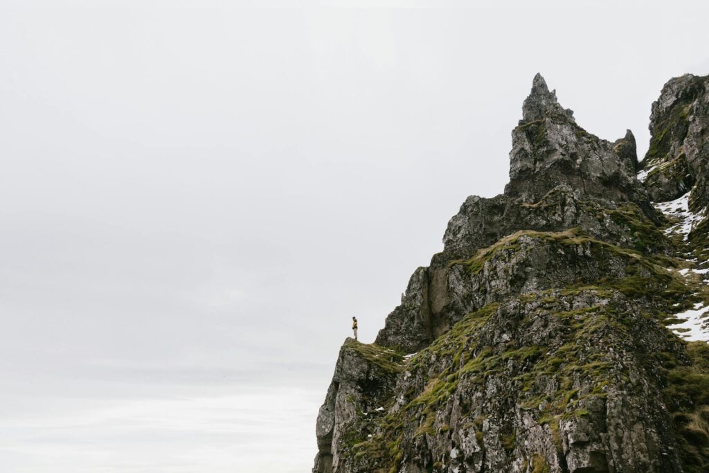 A person standing on peak of rocky mountain
