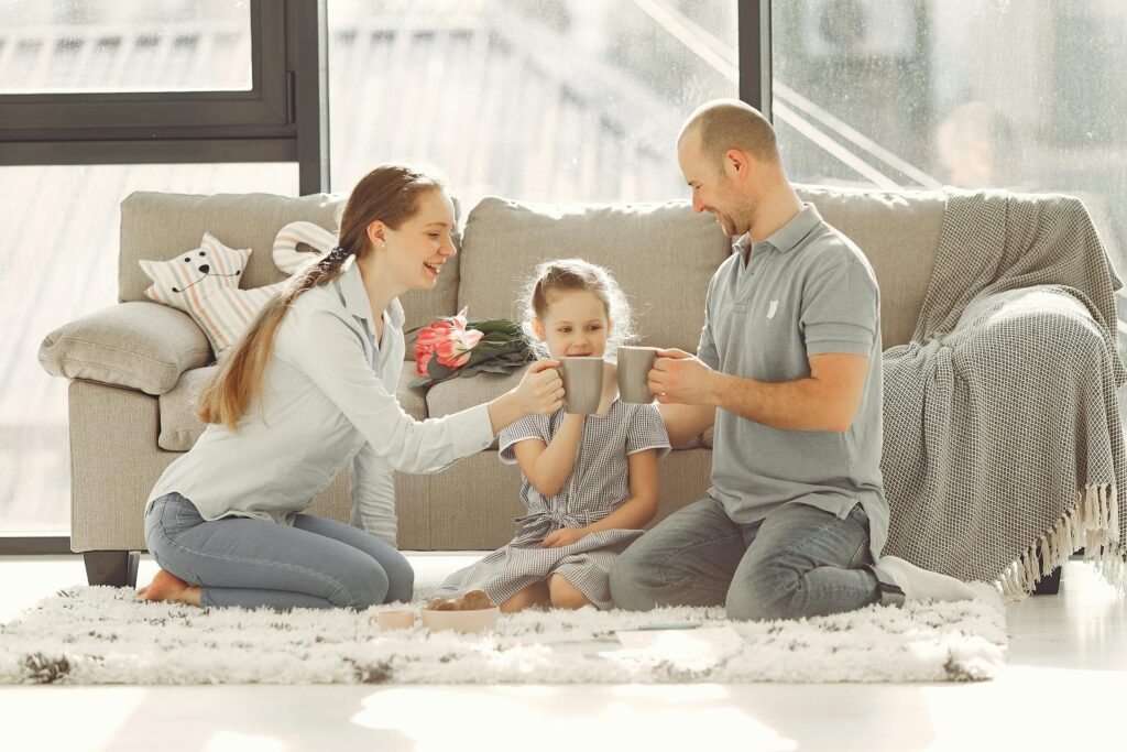 A family having tea sitting on the floor