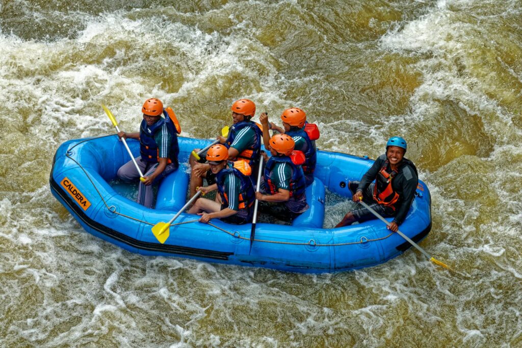 People riding  blue raft on the body of water