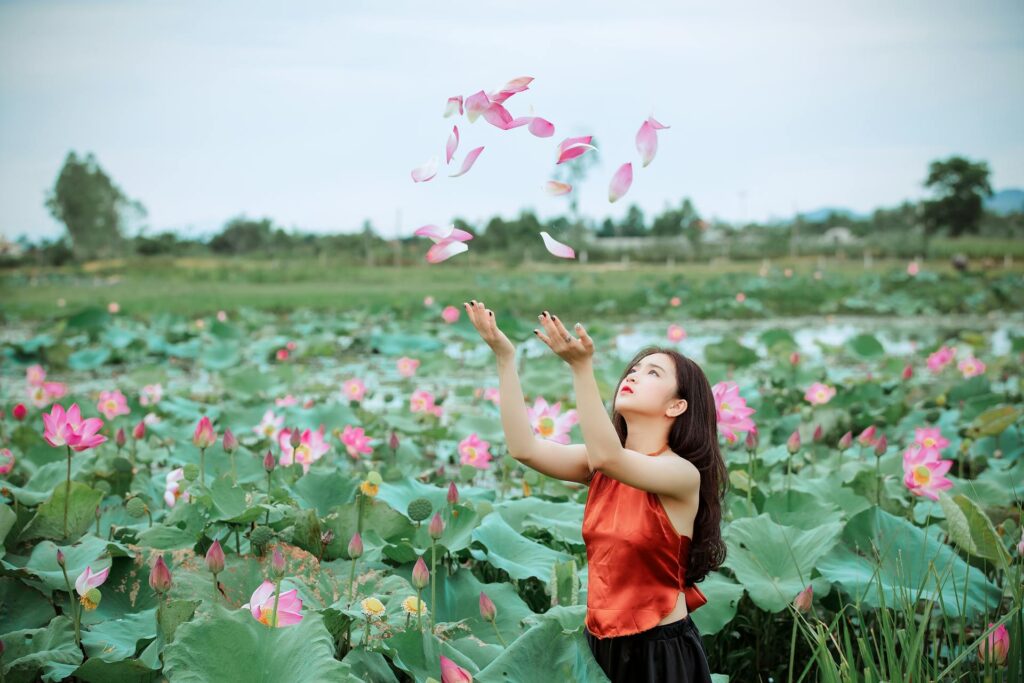 A girl throwing pink petals showing motivational signs